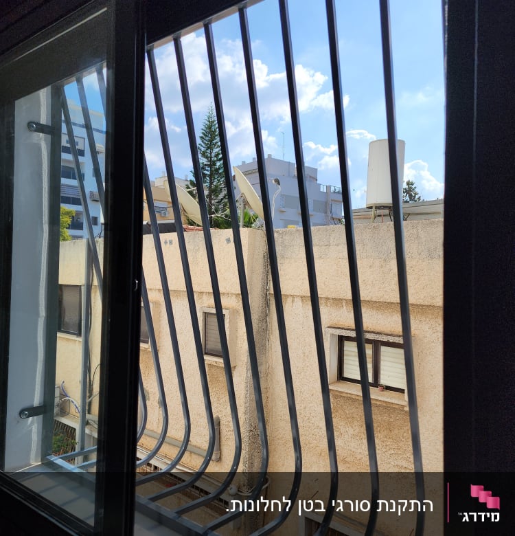 סורגי מתכת על חלון פתוח עם נוף חיצוני